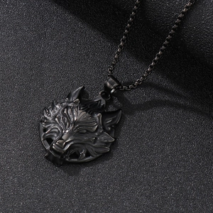Detailed close-up of a carved black stainless steel wolf head pendant on a box chain