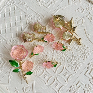 Vintage pink rose jewelry set including floral brooch and green enamel leaf earrings