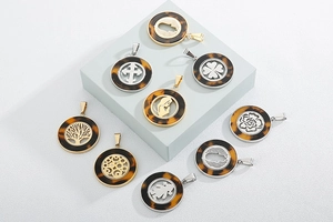 Dettaglio di pendenti rotondi con trama tartarugata e motivi traforati in oro e argento