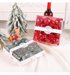 Close-up of red and green Christmas ball gift boxes with assorted hanging ornaments