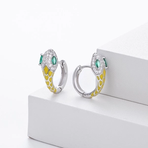 Macro detail of S925 sterling silver snake earrings with green gems and yellow enamel