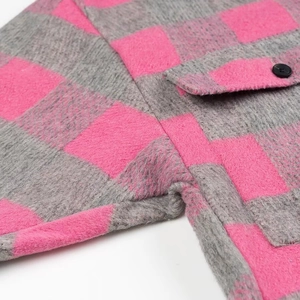 Detail of pink and grey plaid shirt featuring brushed flannel texture and black button