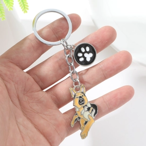 Detail of German Shepherd metal keychain with black paw print charm on a silver keyring