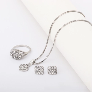 Close-up of silver geometric jewelry set with sparkling rhinestones on white stands
