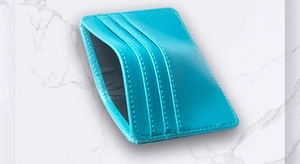 Macro detail of sky blue faux leather card holder with three slots on marble background