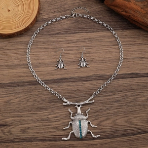 Dettaglio set gioielli coleottero retrò con strass blu su legno scuro