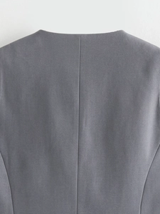 Vue macro de la texture en sergé gris et des coutures détaillées sur un gilet de mode pour femmes
