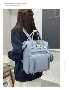 Detail view of the light blue diaper backpack featuring waterproof fabric and side pouch