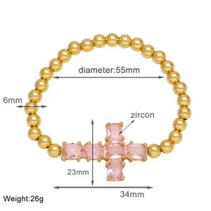 Detailed view of gold cross bracelet with pink zircon stones and dimension markings