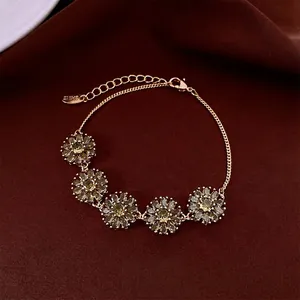 Bracelet fleurs plaqué or 18 carats avec zircons verts sur fond de velours rouge