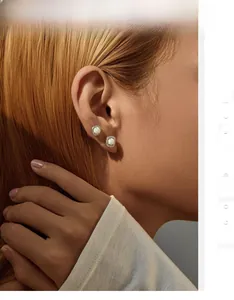 Detailed view of elegant S925 silver opal stud earrings worn by a model in warm light