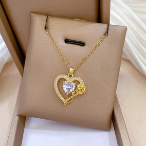 Detailed shot of gold heart necklace featuring a 3D rose and shimmering zircon crystals