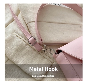 Detail of pink leather strap with silver metal swivel hook on a textured handbag