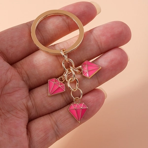 Detailed view of pink enamel diamond-shaped charms on a gold-plated fashion keychain
