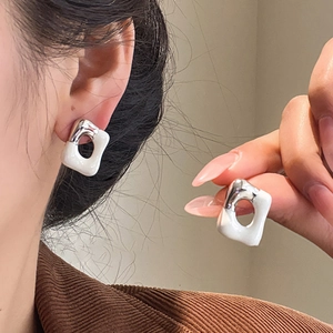 Detail of minimalist white enamel silver-tone square geometric earrings on model