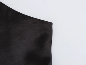 Detailed macro view showing the textured black fabric and premium sheen of the evening gown