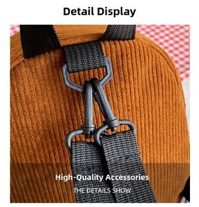 Detail shot of brown corduroy fabric texture and durable black swivel hook on a mini backpack