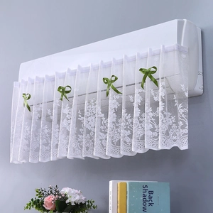 Detail of white lace air conditioner cover with green bow and floral embroidery
