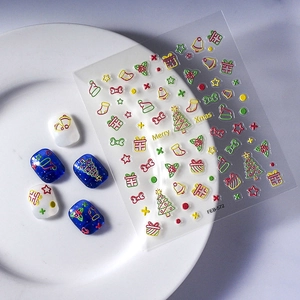 Christmas hollow embossed nail art stickers with festive trees and bells on white ceramic plate