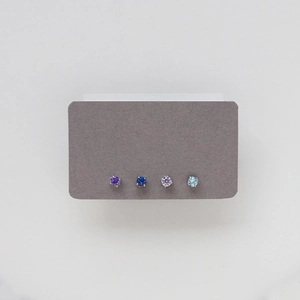 Detailed view of four pairs of titanium steel birthstone stud earrings in vibrant colors