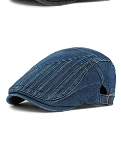 Détail de la casquette gavroche en denim bleu foncé avec coutures et boucle métallique