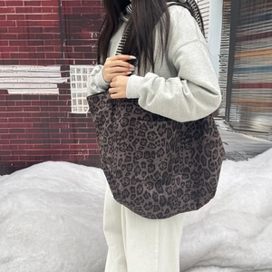 Close-up of pink leopard print suede tote bag with long shoulder straps for daily use