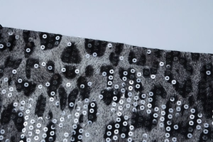 Close-up of leopard print fabric with shimmering silver sequins on mini dress detail