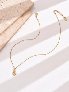 Detail of water drop gold necklace featuring adjustable extension chain and stone pendant