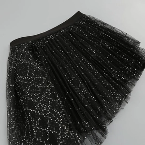 Detailed view of layered black mesh tulle skirt featuring shimmering silver sequins