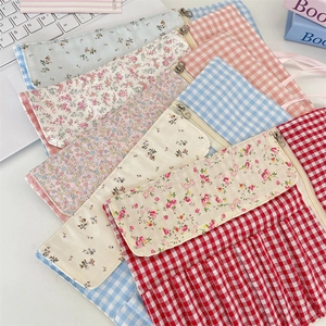 Floral and plaid fabric cosmetic bags for brushes and makeup in a cozy desk setting