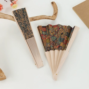 Detail of vintage bohemian patterns on cork folding fans with natural wooden ribs