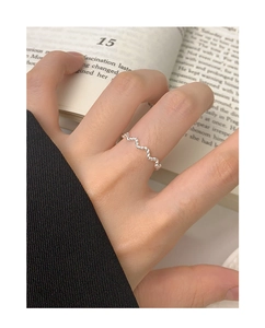 Detail shot of a minimalist S925 sterling silver twisted wave ring worn by a model