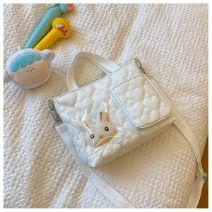Dettaglio borsa a tracolla bianca con trapuntatura a cuore e decorazione a coniglio peluche