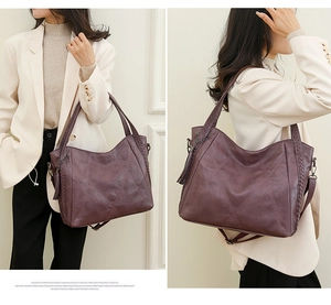 Detail of purple-brown faux leather tote bag with woven strap and tassel decoration