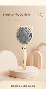 Ergonomic matte handle detail of a beige massage hairbrush with cute bear ear design