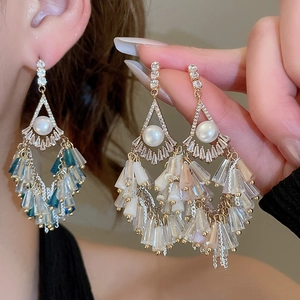 Macro shot of gold tassel earrings with pearls and blue crystal fringe detail