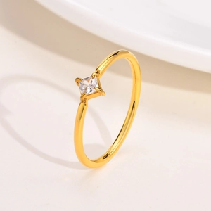 Detailed view of square clear zircon stone with four-prong setting on gold steel ring