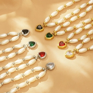 Macro detail of rice pearl necklaces with heart pendants in gold and silver finish
