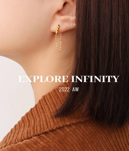 Close-up of minimalist gold geometric chain earrings with textured links on a female model
