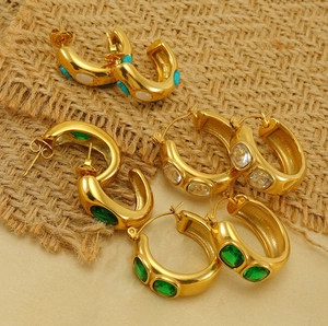 Gros plan sur de grosses créoles vintage en acier plaqué or 18 carats serties de gemmes