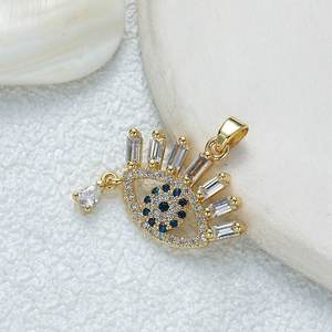 Golden evil eye pendant with blue and white cubic zirconia on white shell background