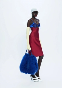Vue détaillée du corset fleuri brodé et jupe en satin rouge avec sac à main en peluche