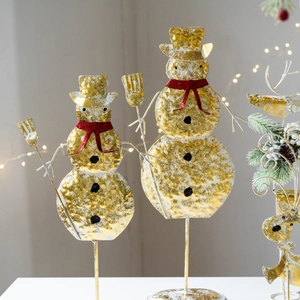 Golden wrought iron Christmas snowman figures with red scarves for holiday table decor