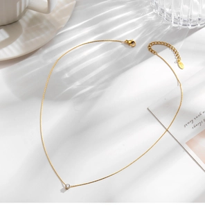 Close-up of 18K gold bamboo chain necklace with a sparkling cubic zirconia pendant