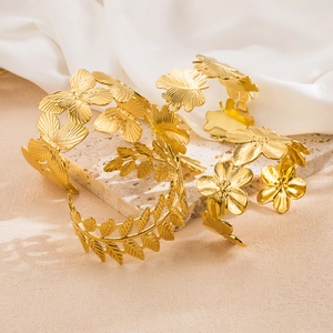 Detailed view of four gold-tone adjustable cuffs featuring leaf and butterfly designs
