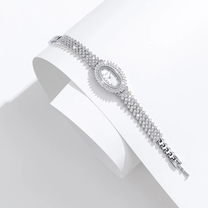 Close-up of luxury silver oval watch encrusted with diamonds and a 375 gold mark