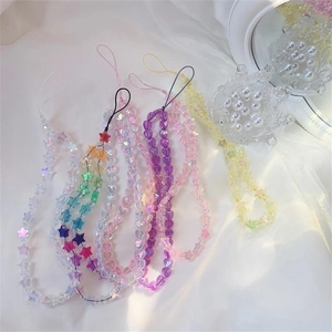 Close-up of colorful acrylic heart and star beaded phone straps on white silk background