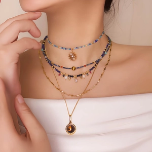 French vintage layered beaded necklace set with sun and cat charms on a female model