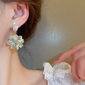 Detailed view of floral drop earrings with sparkling crystals and translucent petals