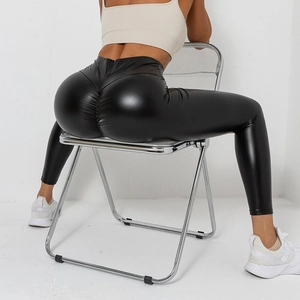 Detailed close-up of high-waisted black shiny leggings with a scrunch butt lifting effect